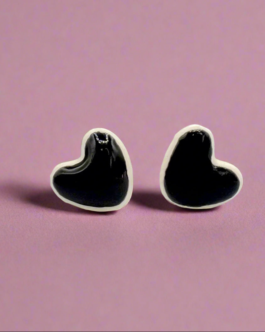 Heart-shaped black and silver earrings on a white background