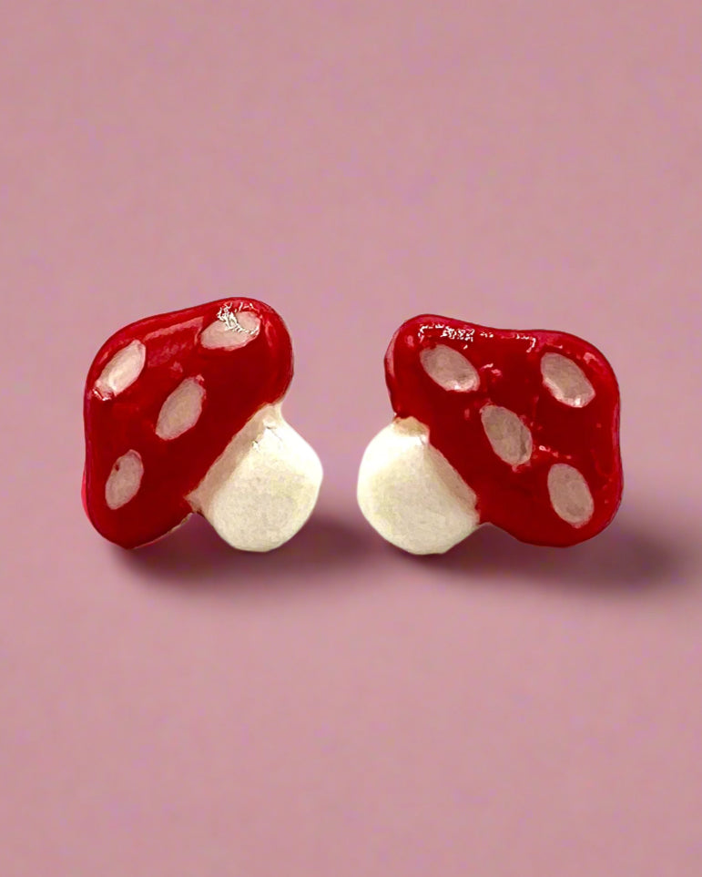 Red mushroom-shaped earrings on a white background