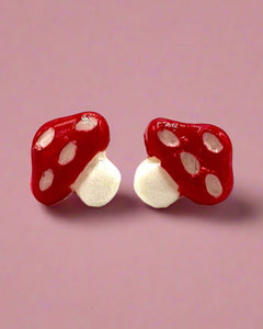 Red mushroom-shaped earrings on a white background