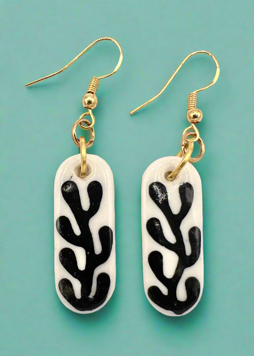 Pair of earrings with black and white coral pattern on a white background