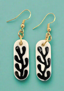 Pair of earrings with black and white coral pattern on a white background